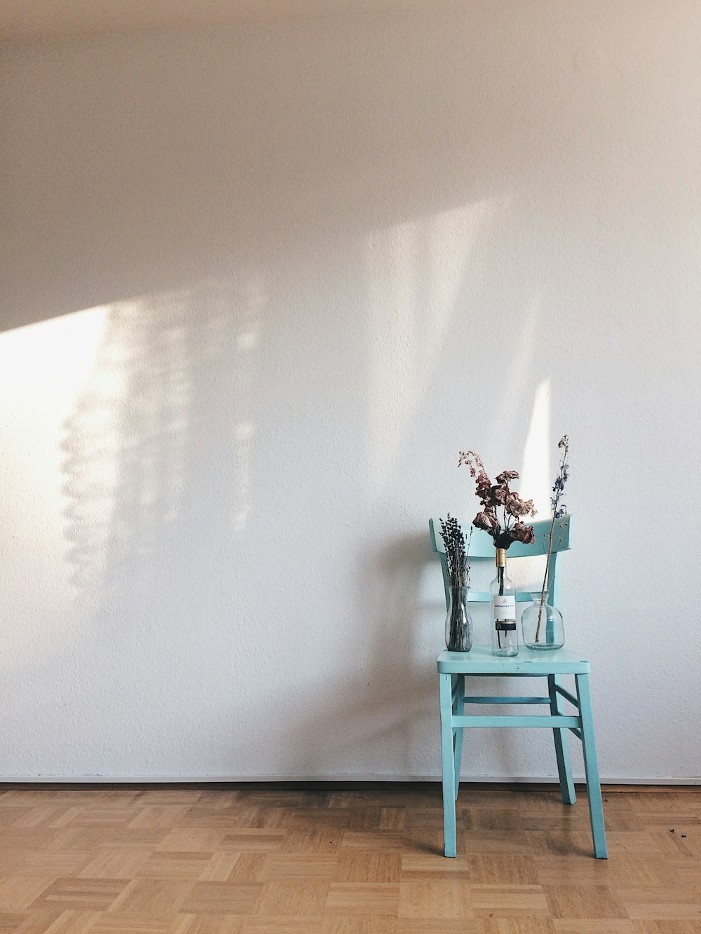 a blue chair sitting in front of a white wall