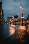 a cobblestone street at night with lights and buildings in the background