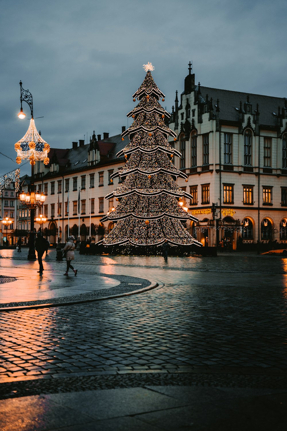 a lit christmas tree in the middle of a town square