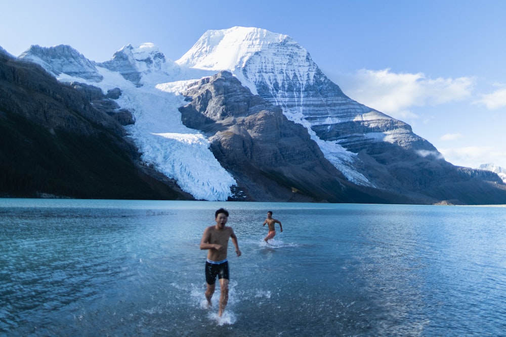 a couple of people that are standing in the water