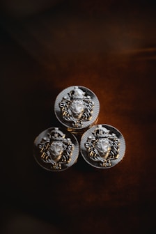three metal buttons with a lion head on them