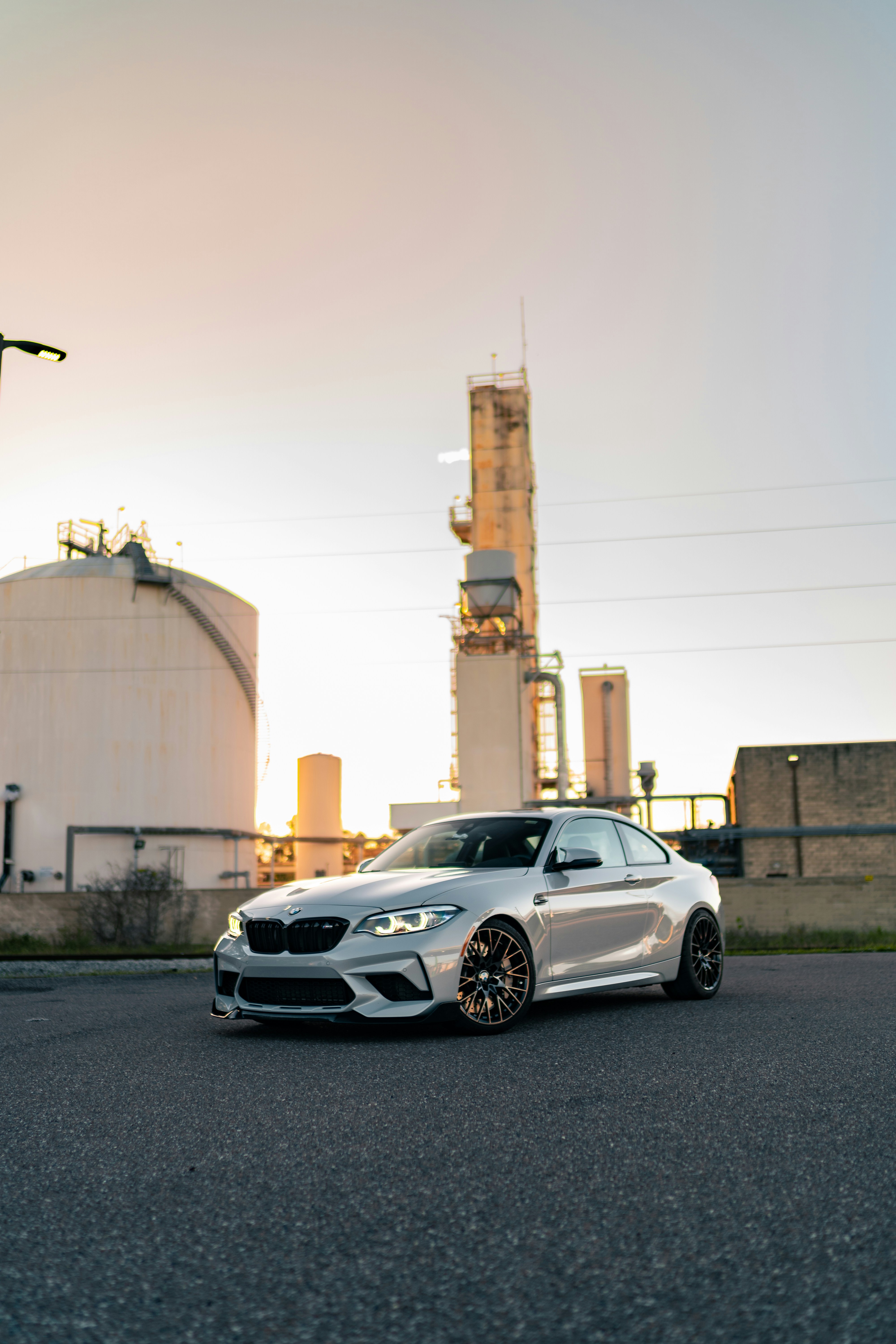 A white car parked in front of a factory