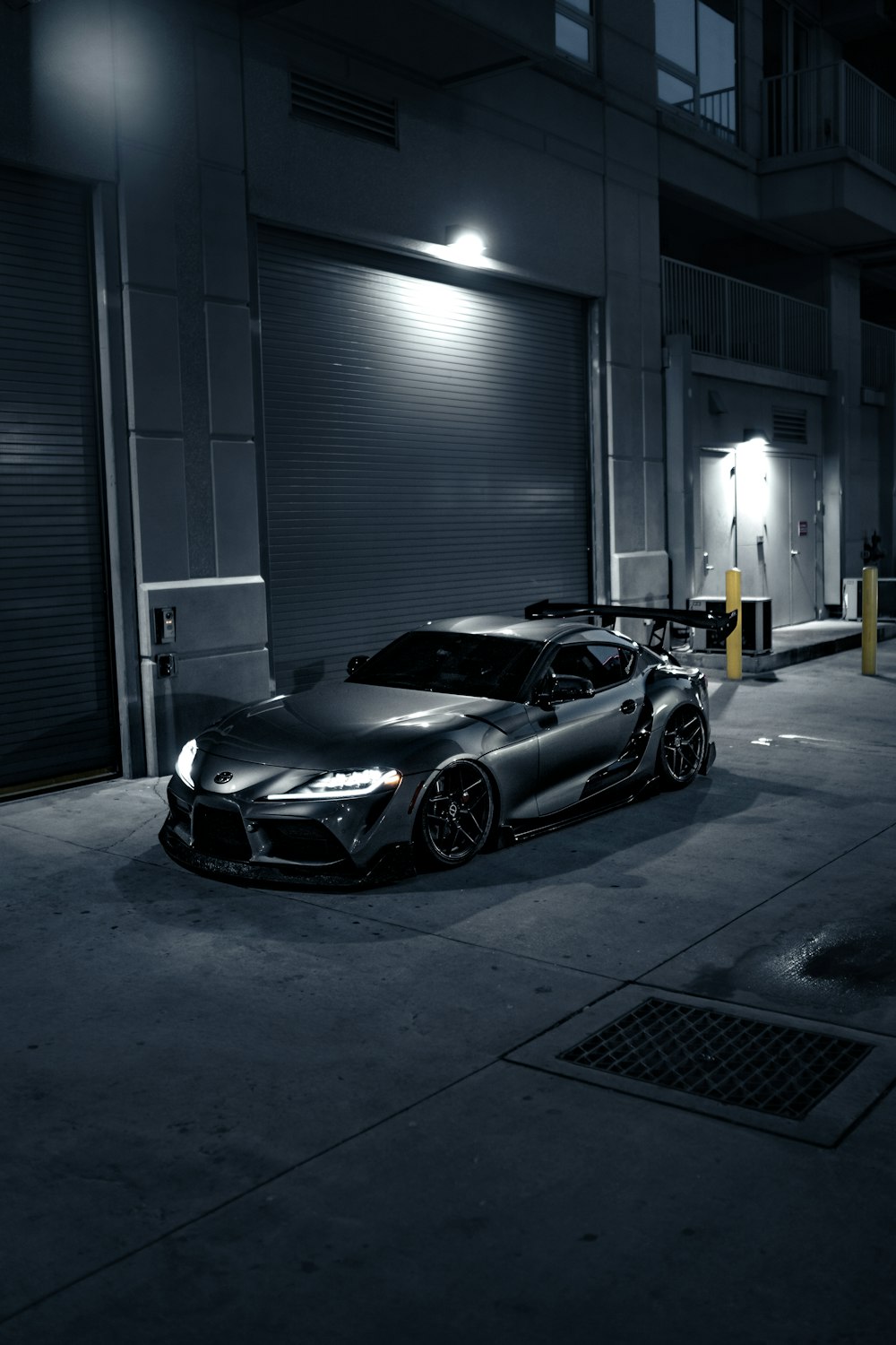 two cars parked in a parking lot at night