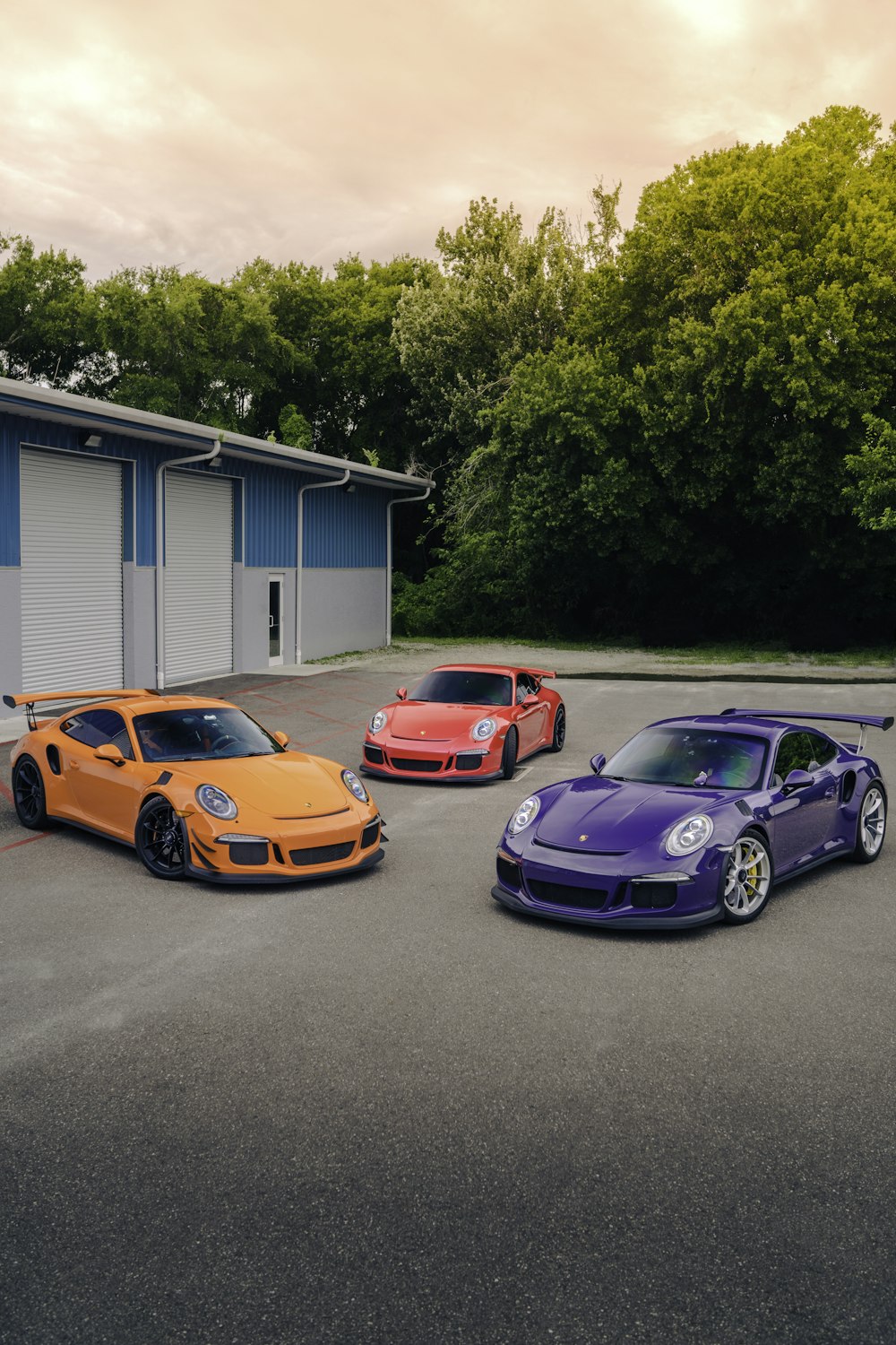 three different colored cars parked in a parking lot