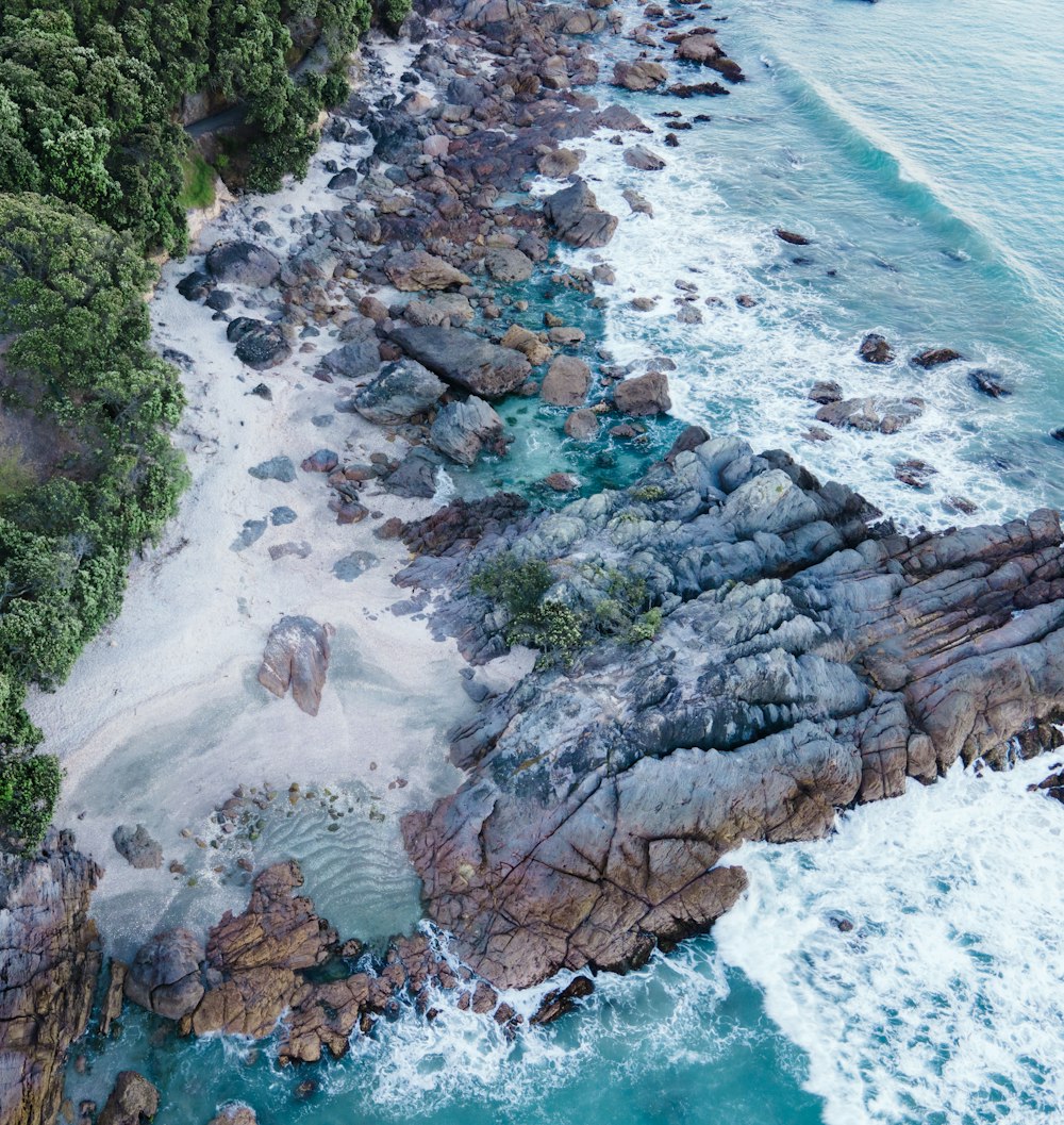 an aerial view of a rocky beach and ocean