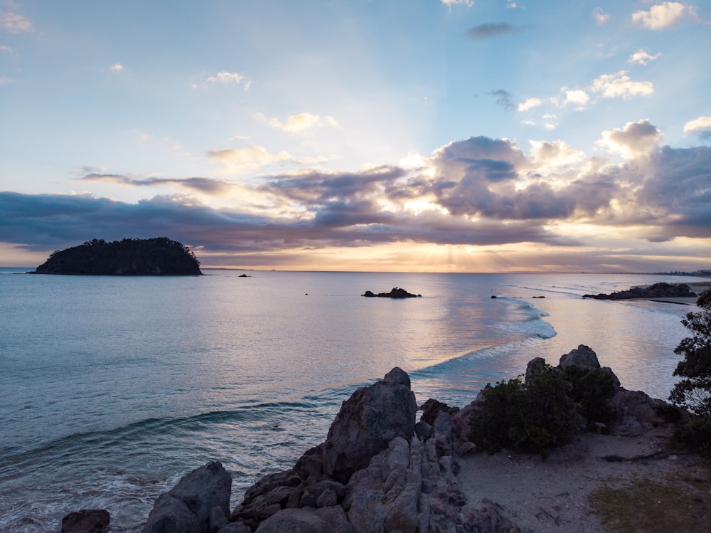 Il sole sta tramontando sull'oceano e sulle rocce