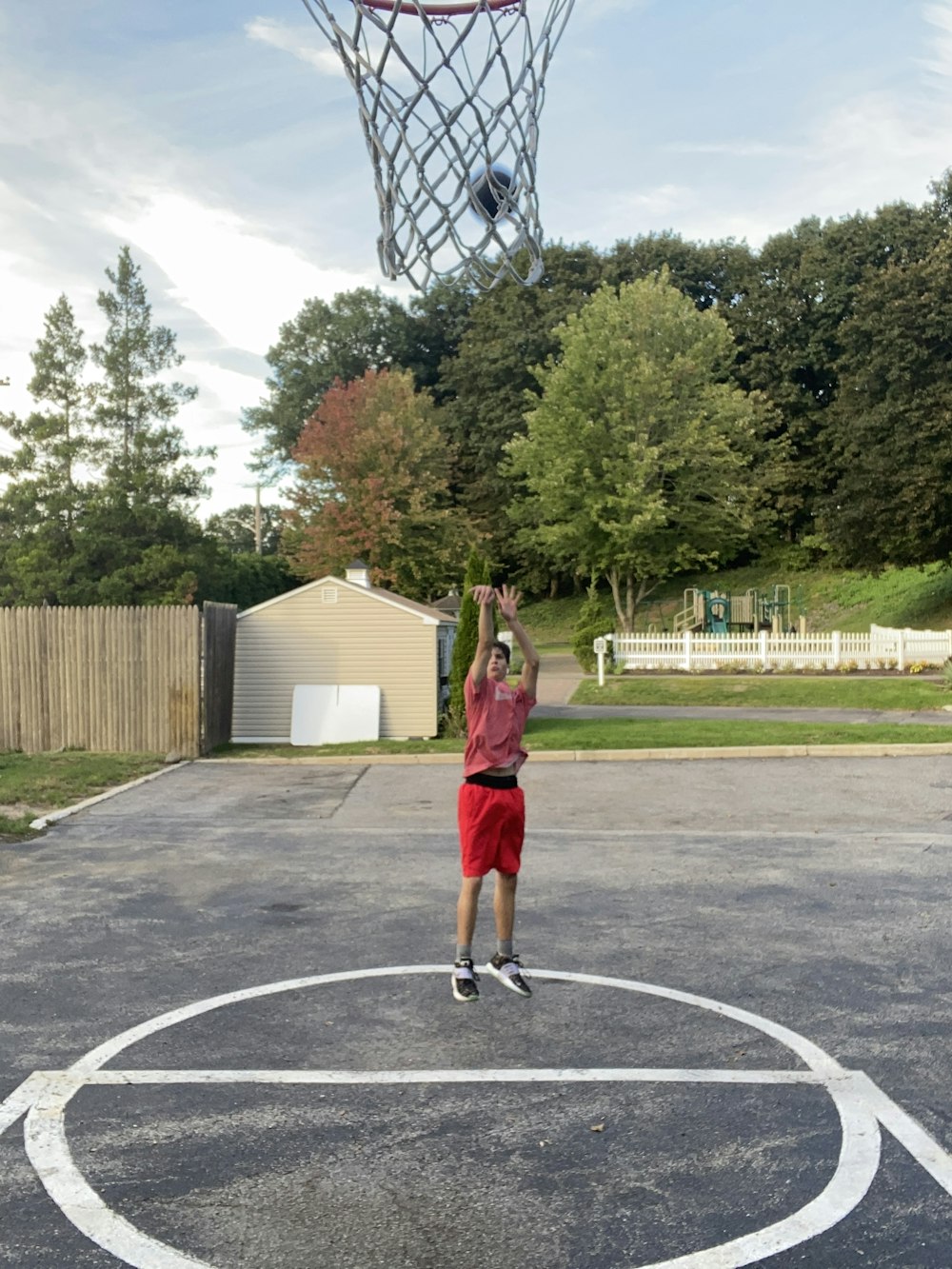 a man in a red shirt is playing basketball