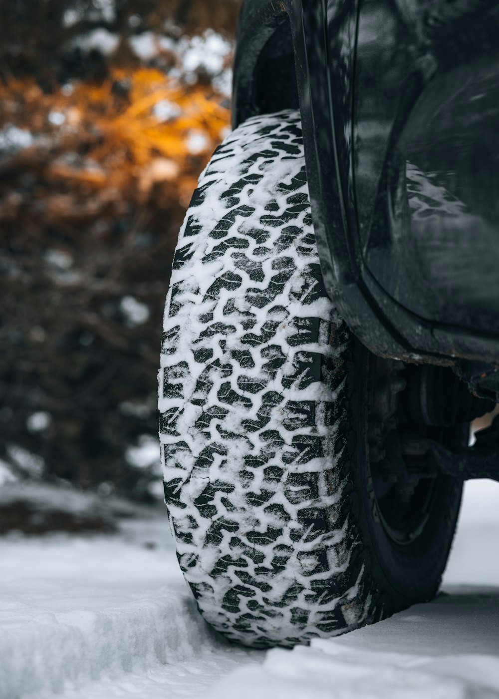 the tire of a truck is covered in snow