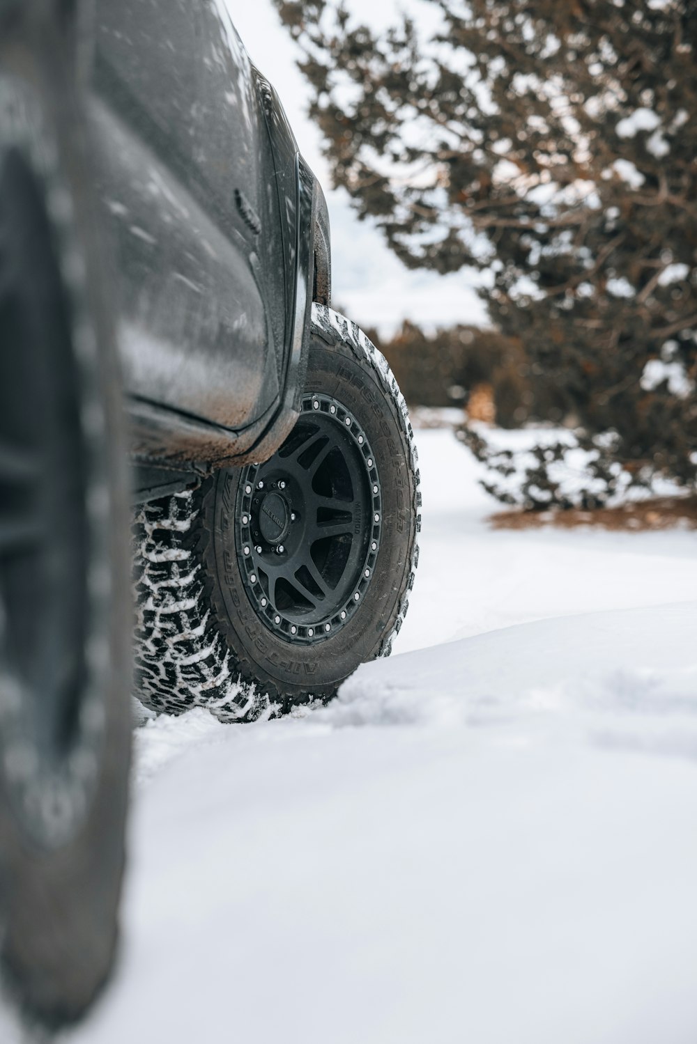 a truck is parked in the snow near some trees