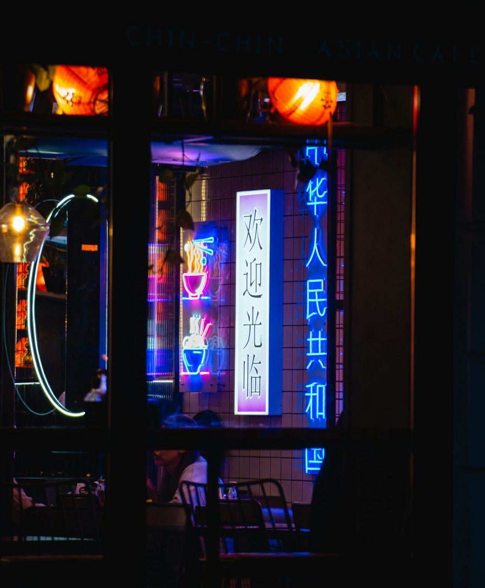 a restaurant with a neon sign in the window