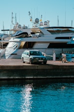 a car parked on a dock next to a boat