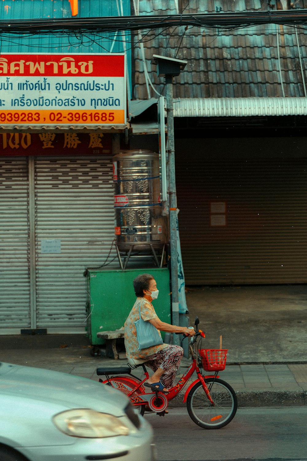 a woman riding a red bike down a street