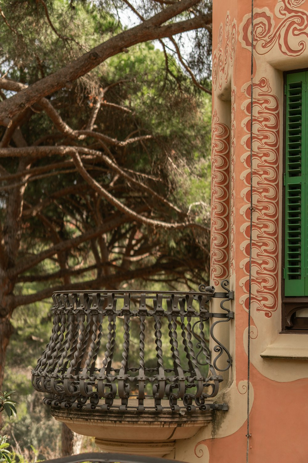 a balcony with a green window and a wrought iron railing