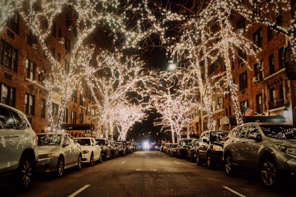 a street filled with lots of parked cars next to tall buildings