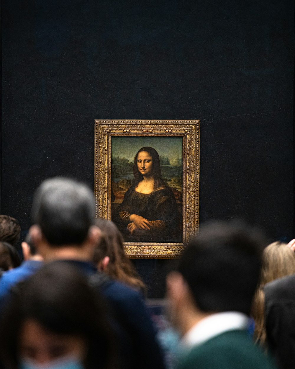 a crowd of people looking at a painting