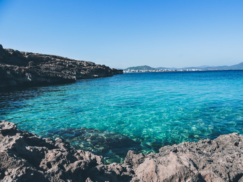 a body of water surrounded by rocky shore