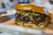 Close-up of a colorful food truck serving a delicious gourmet burger with fresh toppings.