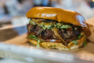 Close-up of a colorful food truck serving a delicious gourmet burger with fresh toppings.