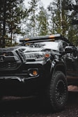 A sturdy black off-road SUV parked on a rugged trail.