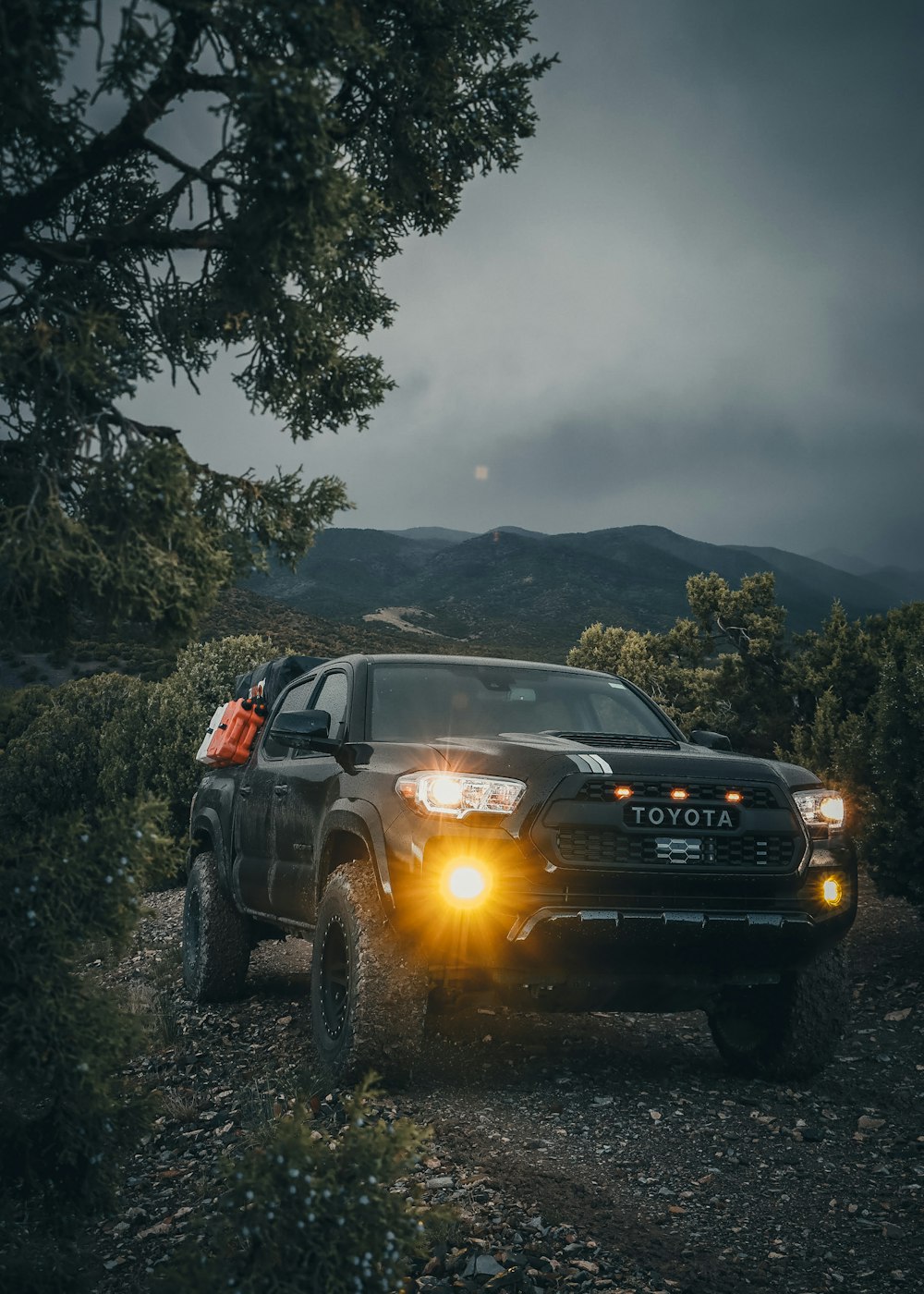 a black toyota truck parked on a dirt road