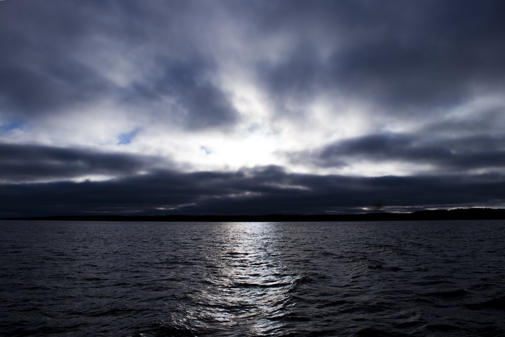 a body of water under a cloudy sky