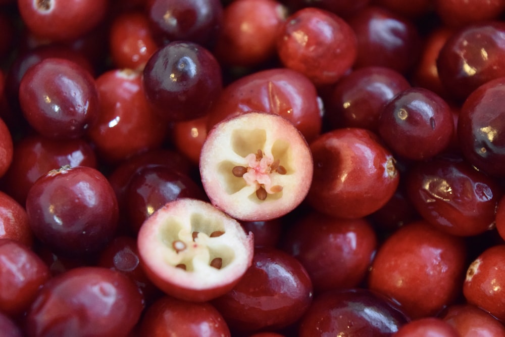 a pile of cherries with one cut in half