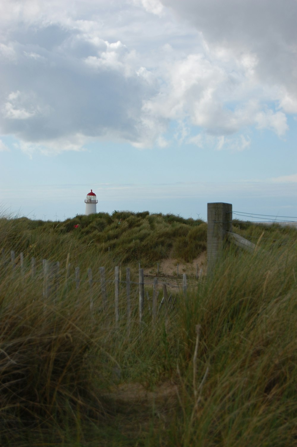 un phare au sommet d’une colline herbeuse