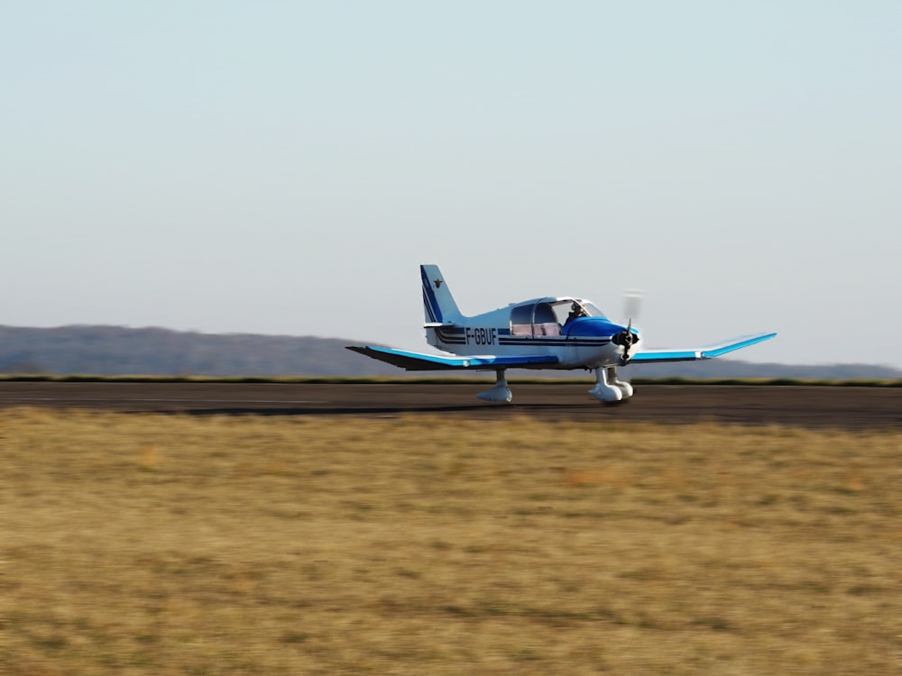 a small blue and white plane on a runway
