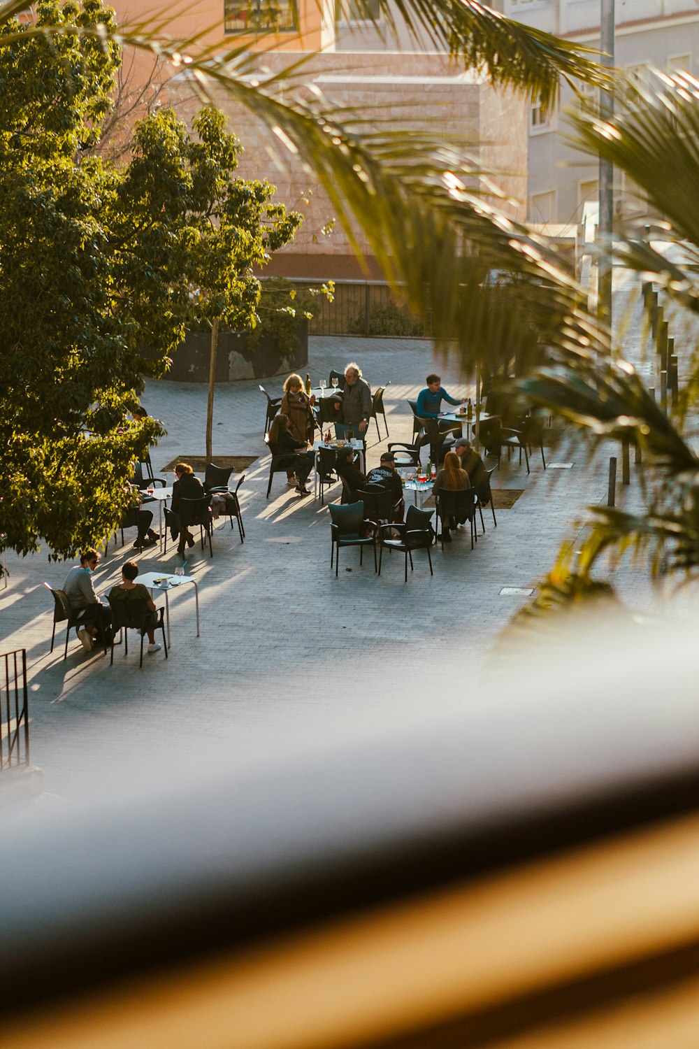 a group of people sitting at tables on a sidewalk