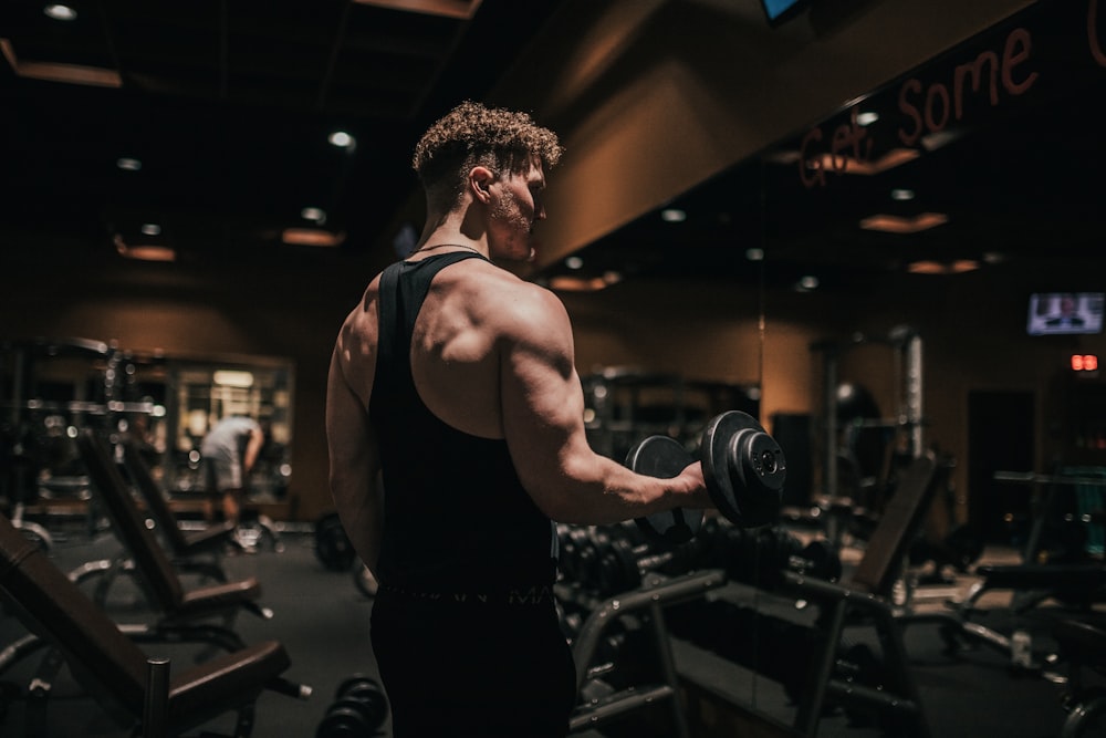 a man holding a dumbbell in a gym