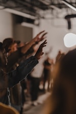 a group of people standing in a room with their hands up