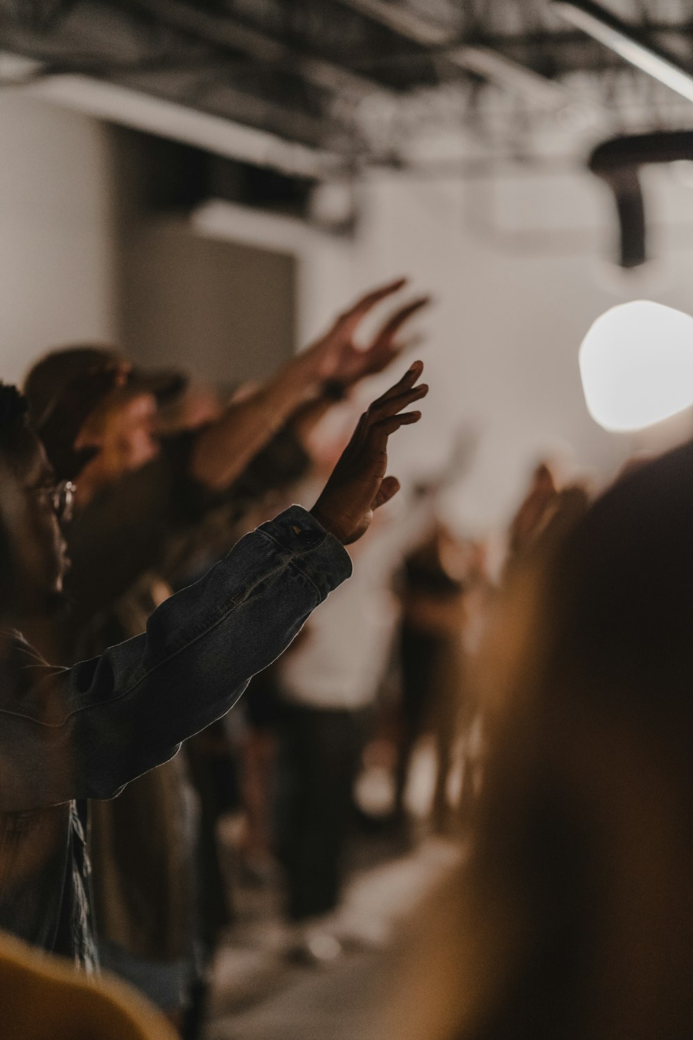 a group of people standing in a room with their hands up