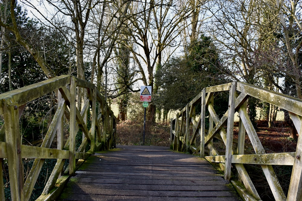 eine Holzbrücke mit einem Schild darauf