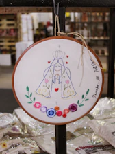 Close-up of a beautifully embroidered wedding hoop featuring floral patterns and elegant lettering.