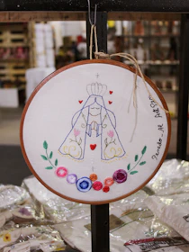Close-up of a beautifully embroidered wedding hoop featuring floral patterns and elegant lettering.
