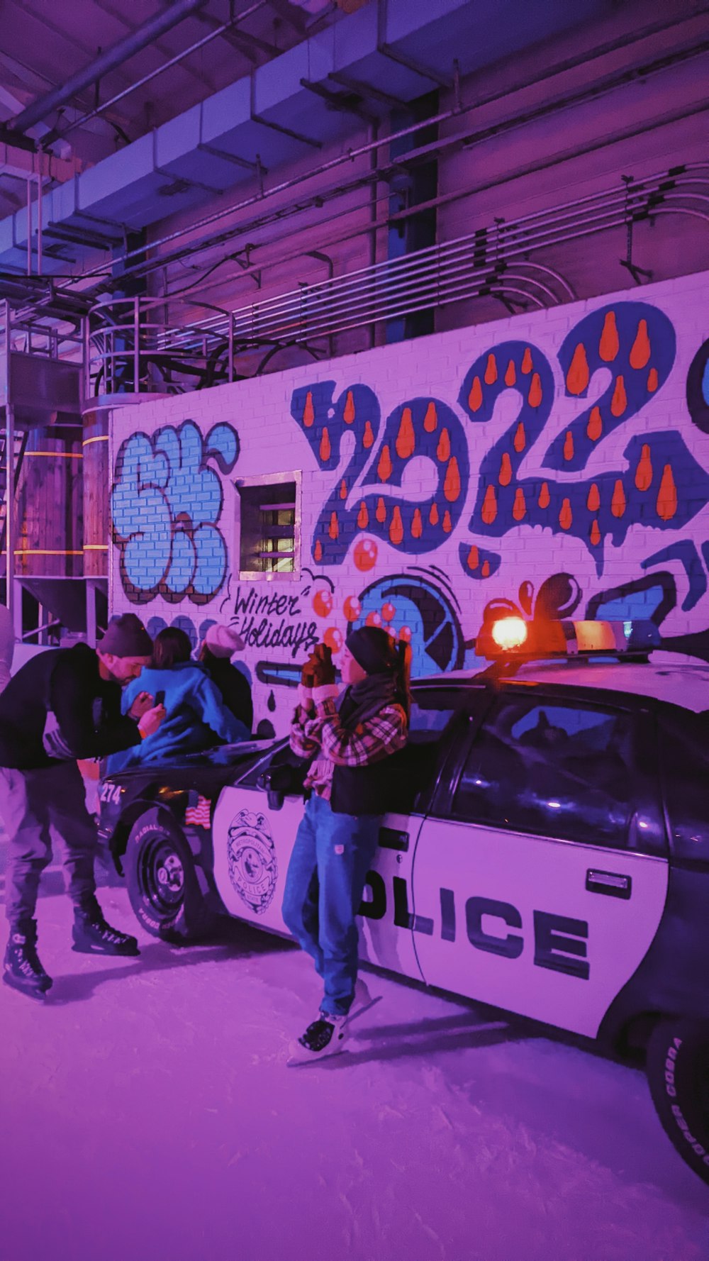 a police car parked in front of a wall with graffiti on it