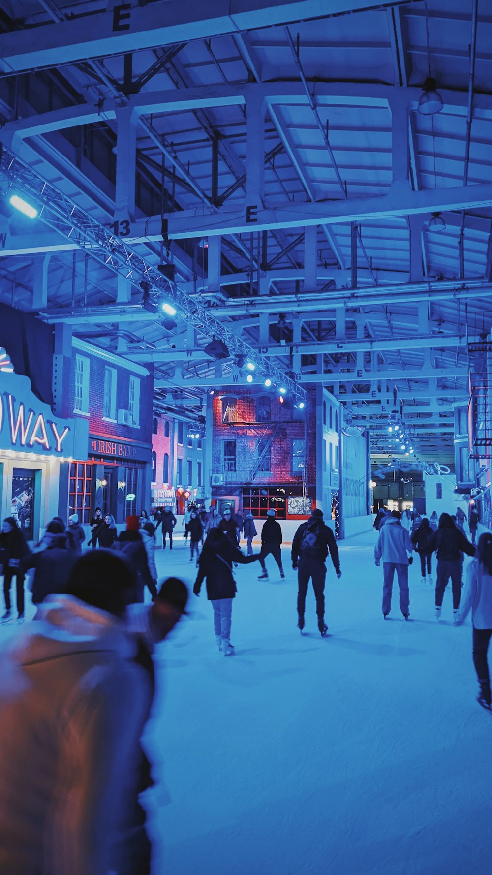 a group of people skating on an indoor ice rink