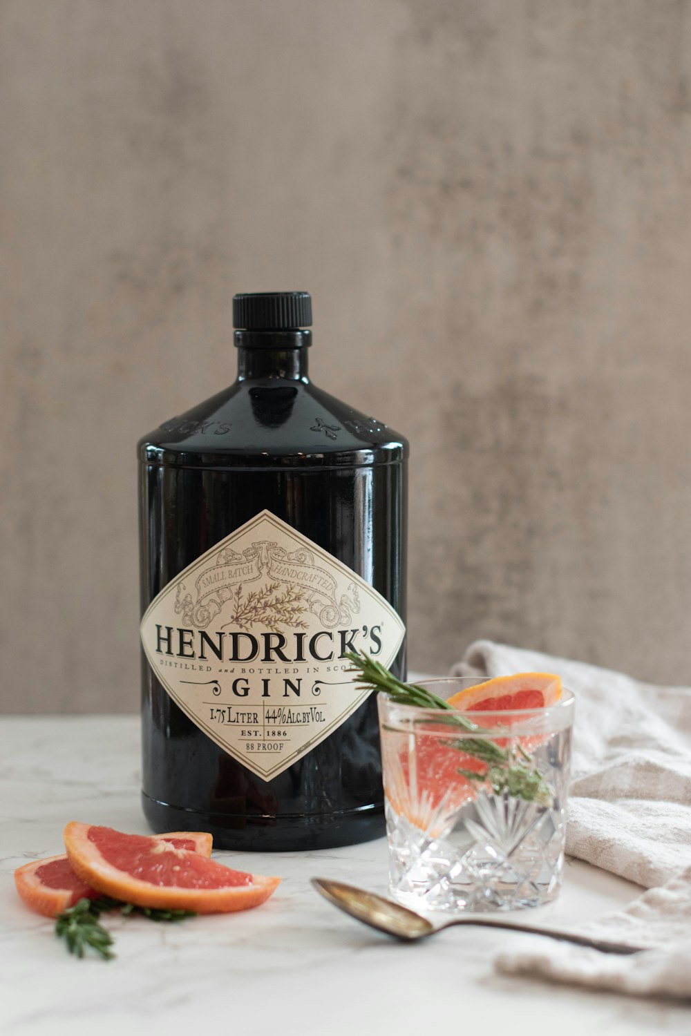 a bottle of hendrick's gin next to a glass of gin