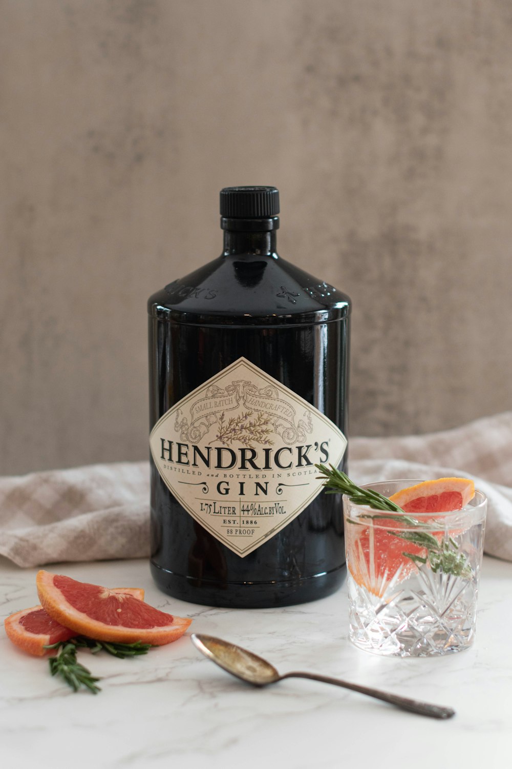 a bottle of hendirick's gin with grapefruit garnish