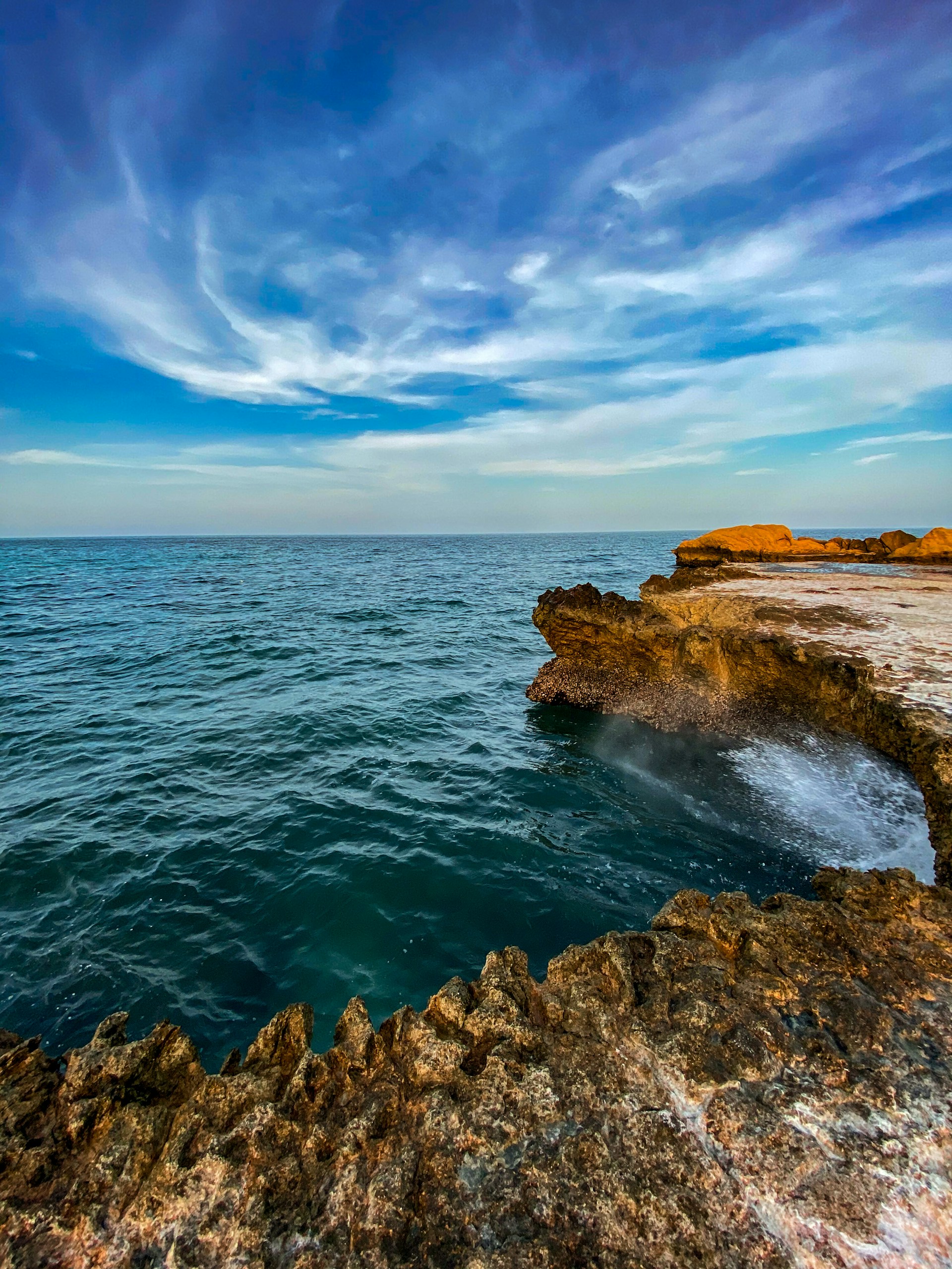 a body of water sitting next to a rocky cliff