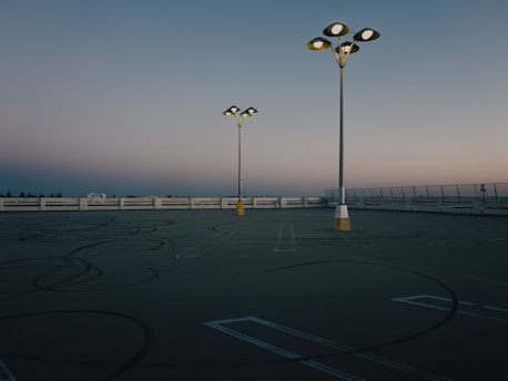 a couple of street lights sitting on top of a parking lot