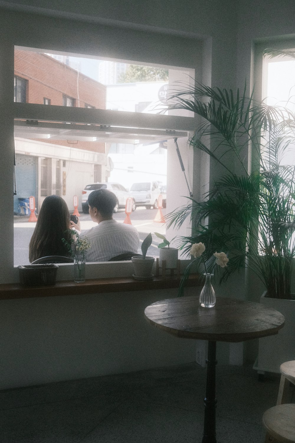 a couple of people sitting at a table in front of a window