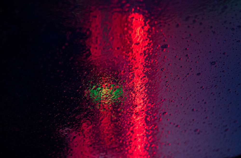 a close up of a red traffic light on a rainy day