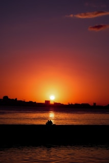 the sun is setting over a body of water