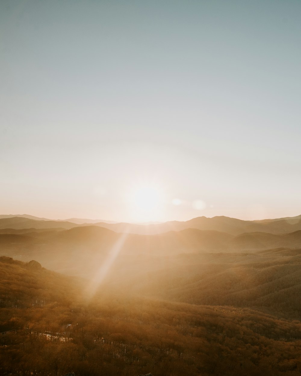 the sun is setting over a mountain range