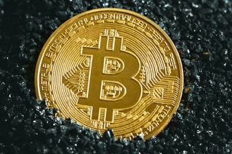 a bitcoin sitting on top of a black surface