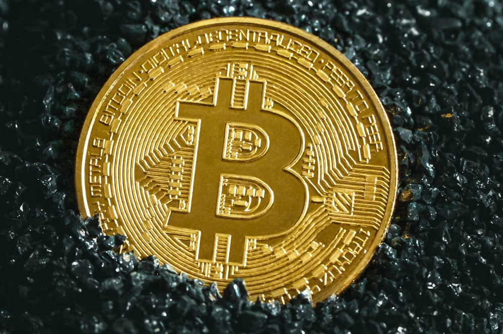 a bitcoin sitting on top of a black surface