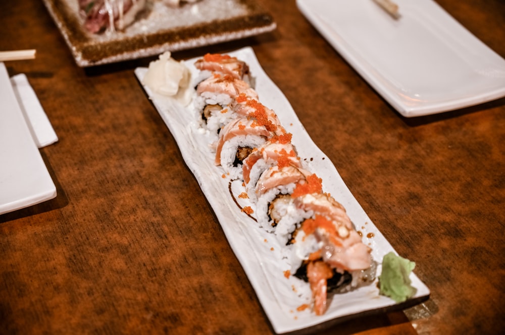 a plate of sushi on a wooden table