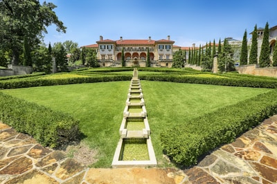 A beautifully landscaped garden surrounding a mansion.