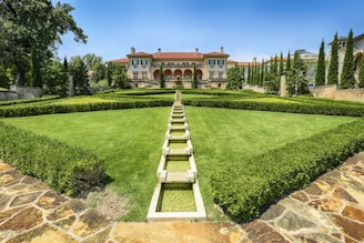 A beautifully landscaped garden surrounding a mansion.